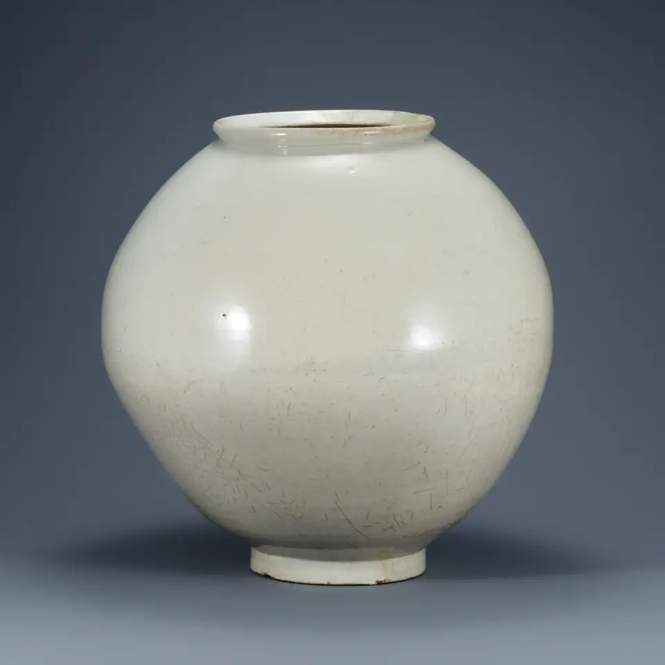 Round white porcelain moon jar with a short rim and a soft, uneven belly